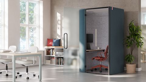 An angle view of Bay Work Pod in a touchdown space with Layout Studio in the foreground and an OE1 curtain in the background.