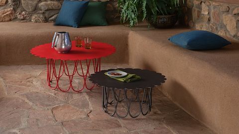 An outdoor sitting area featuring a red and black Girard Flower Table
