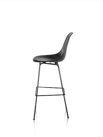 Profile view of a black Eames Molded Fiberglass Stool. 