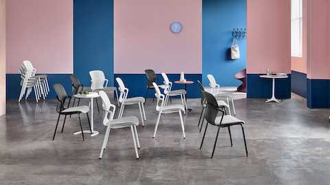 Several black and white Keyn side chairs in a large meeting space with additional chairs stacked on the side.