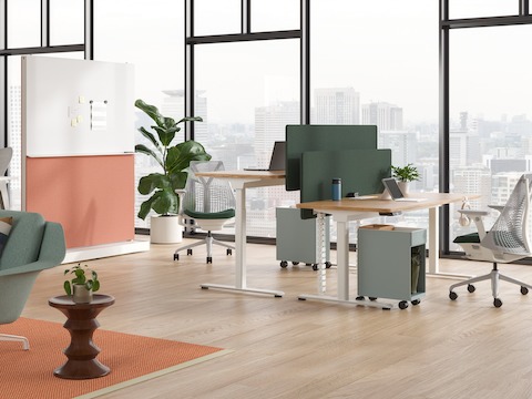 A pair of freestanding Nevi Sit-to-Stand Desks with the back desk lowered and Sayl Chairs