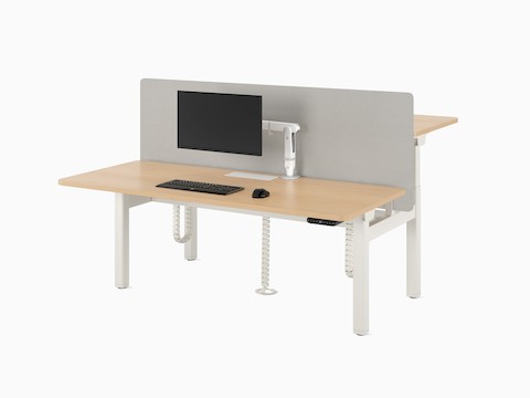Nevi Sit-to-Stand Desks in a back-to-back two-desk configuration in white, with a light coloured worksurface, a fabric screen and a floor umbilical.