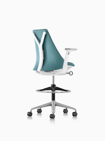 Three-quarter rear view of a blue Sayl Stool with an upholstered back.