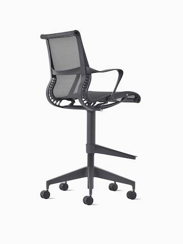 Rear-angle view of a Setu Stool with arms in dark grey.