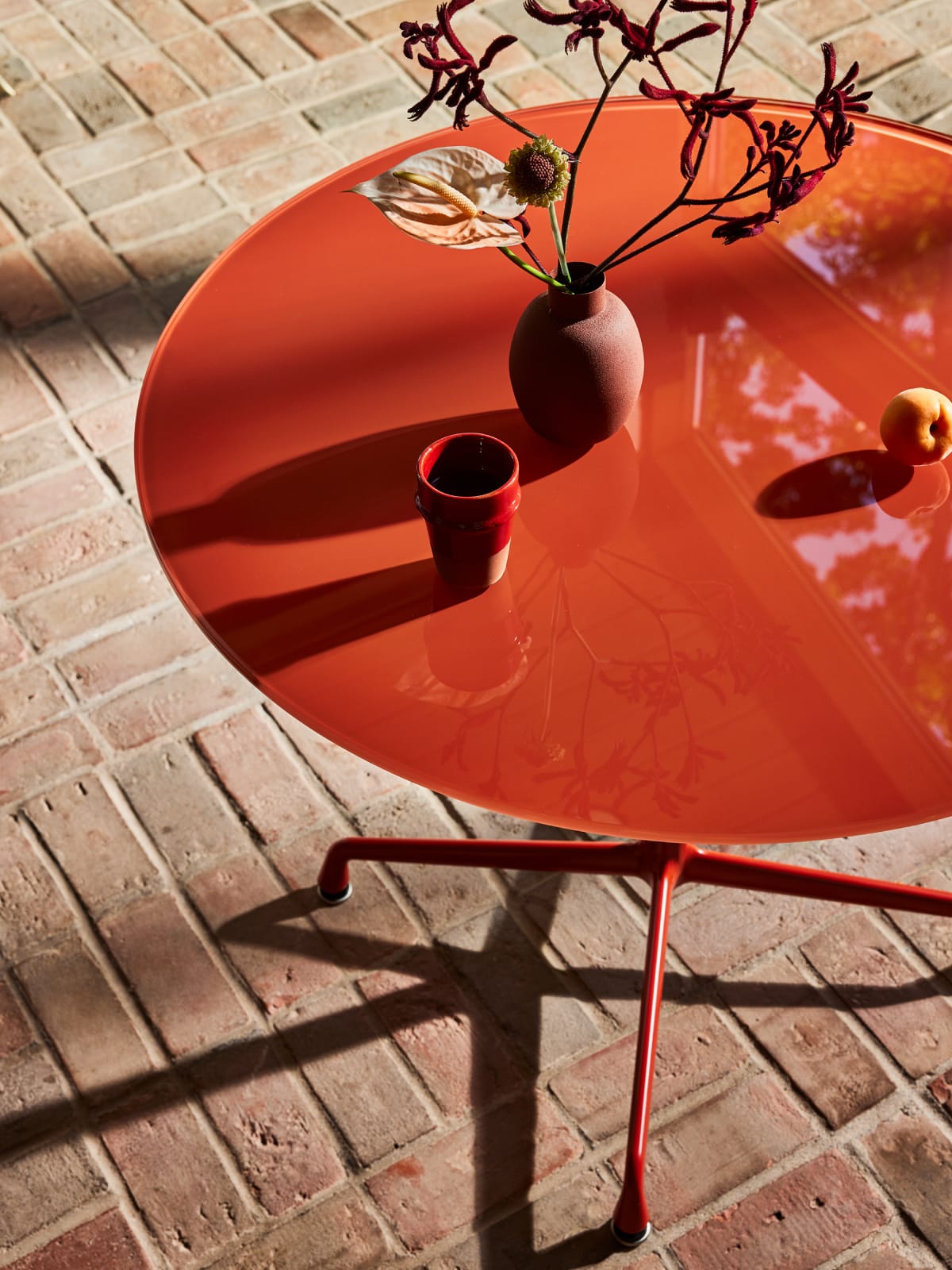 Herman Miller x HAY Eames Universal Base Round Table in iron red.