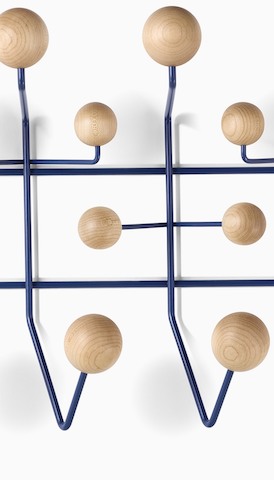 Primer plano de Eames Hang-It-All con perillas de madera para colgar el almacenamiento. Seleccione para ir a la página del producto Accesorios.