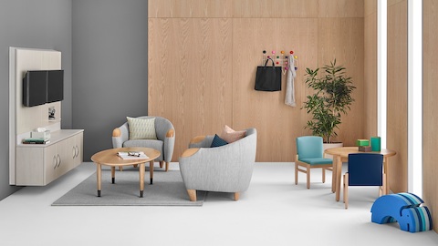 A healthcare lounge featuring grey club chairs and blue side chairs.