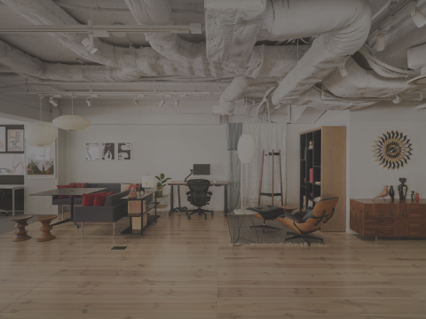 Tokyo showroom overall view with an Eames Lounge Chair and Ottoman, an Aeron Chair viewed from the back, Nelson Bubble Lamps hanging from a ceiling, and Geiger Domino Storage in the forefront.