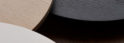 Overhead view of three overlapping round table tops in white, tan, and black.