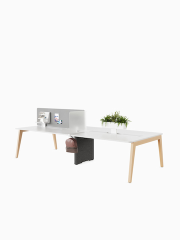 Byne System with wooden Sylvain legs in a 4-seat bench setting, a desk-up screen, planter box and lateral screen.