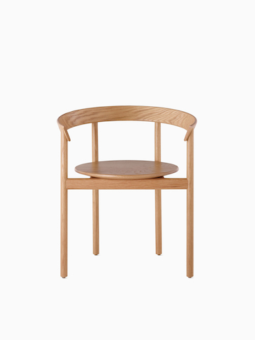 An oak Comma Chair with arms, viewed from the front.