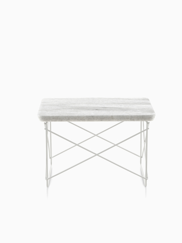 An Eames Wire Base low outdoor table with a stone top.