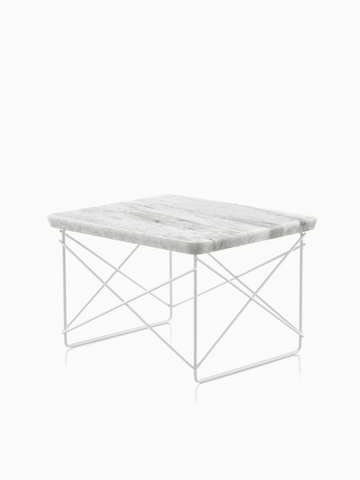 An Eames Wire Base low outdoor table with a stone top.  Select to go to the Eames Wire Base Low Table Outdoor product page.