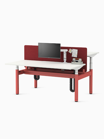Back-to-back Ratio height-adjustable desks positioned at seating and standing heights, with back-to-back shared privacy screen and a high capacity tray on a white sweep.